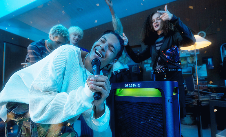 A person singing into the ULTMIC1 leaning in front of the TOWER 9 speaker