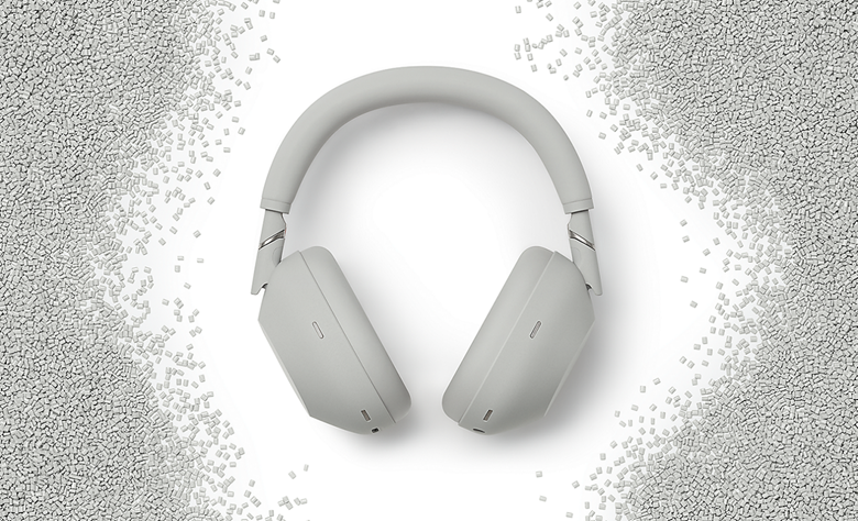 Silver WH-1000XM6 headphones crafted from recycled materials, surrounded by white plastic pellets.