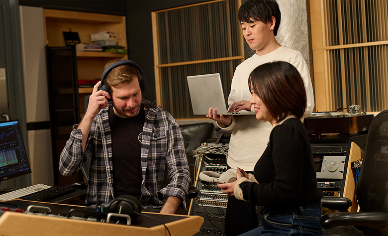 Audio engineers discussing headphone sound quality during a studio session.