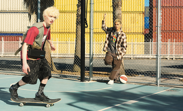 One person on a skateboard carrying the ULT FIELD 3 speaker over their shoulder